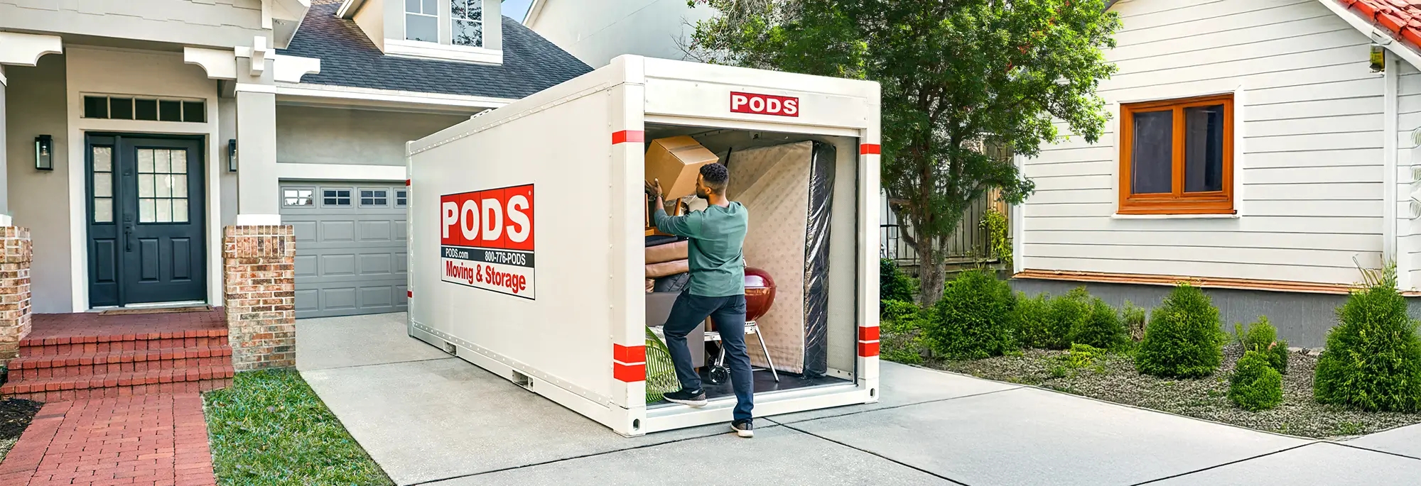 A man packs a box into a PODS container